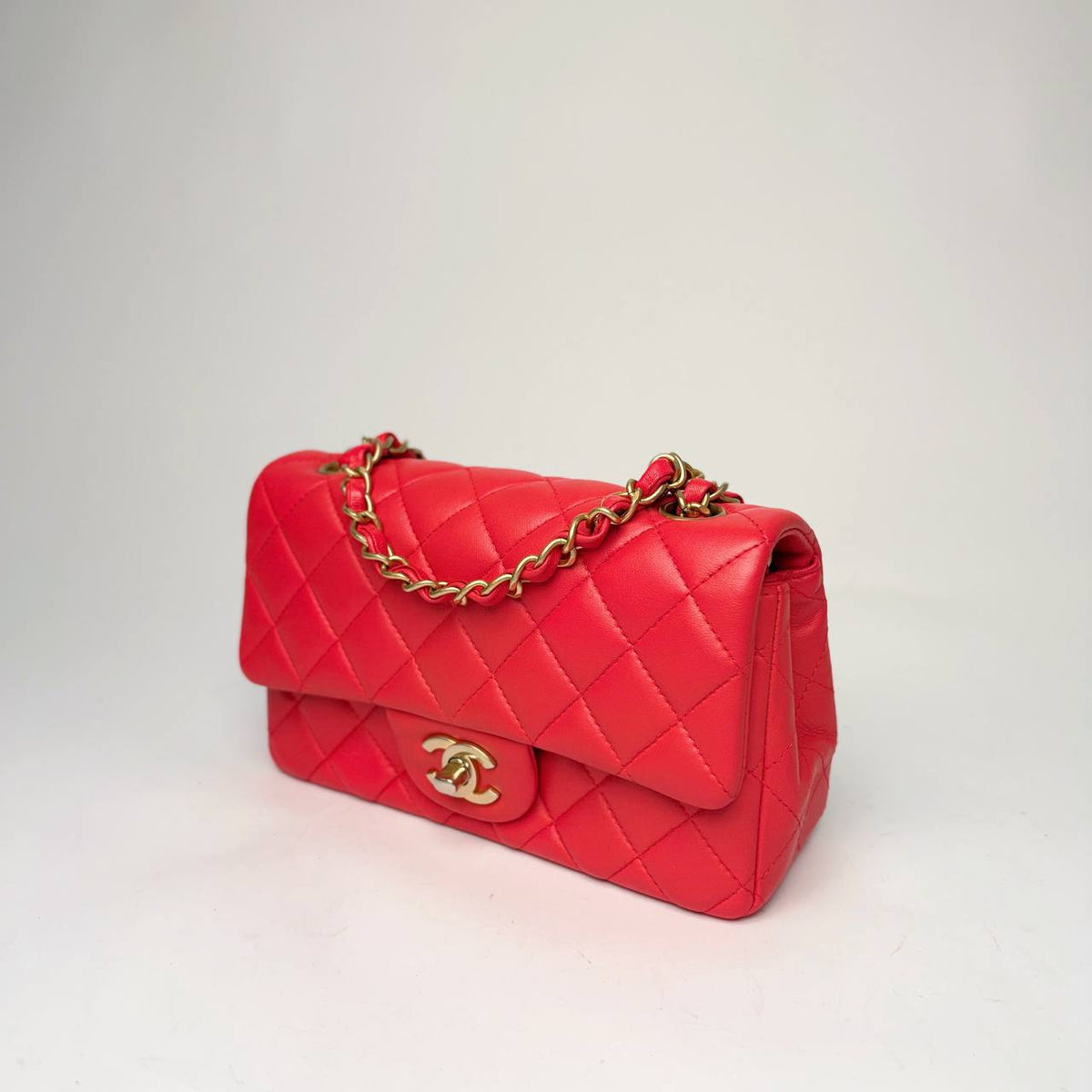 Chanel Mini Rectangular Flap Bag red, angled side view with leather-woven chain