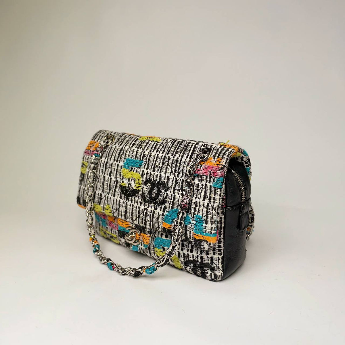 Chanel Easy Flap Bag multicolor tweed, three-quarter side view showing the black leather side panel