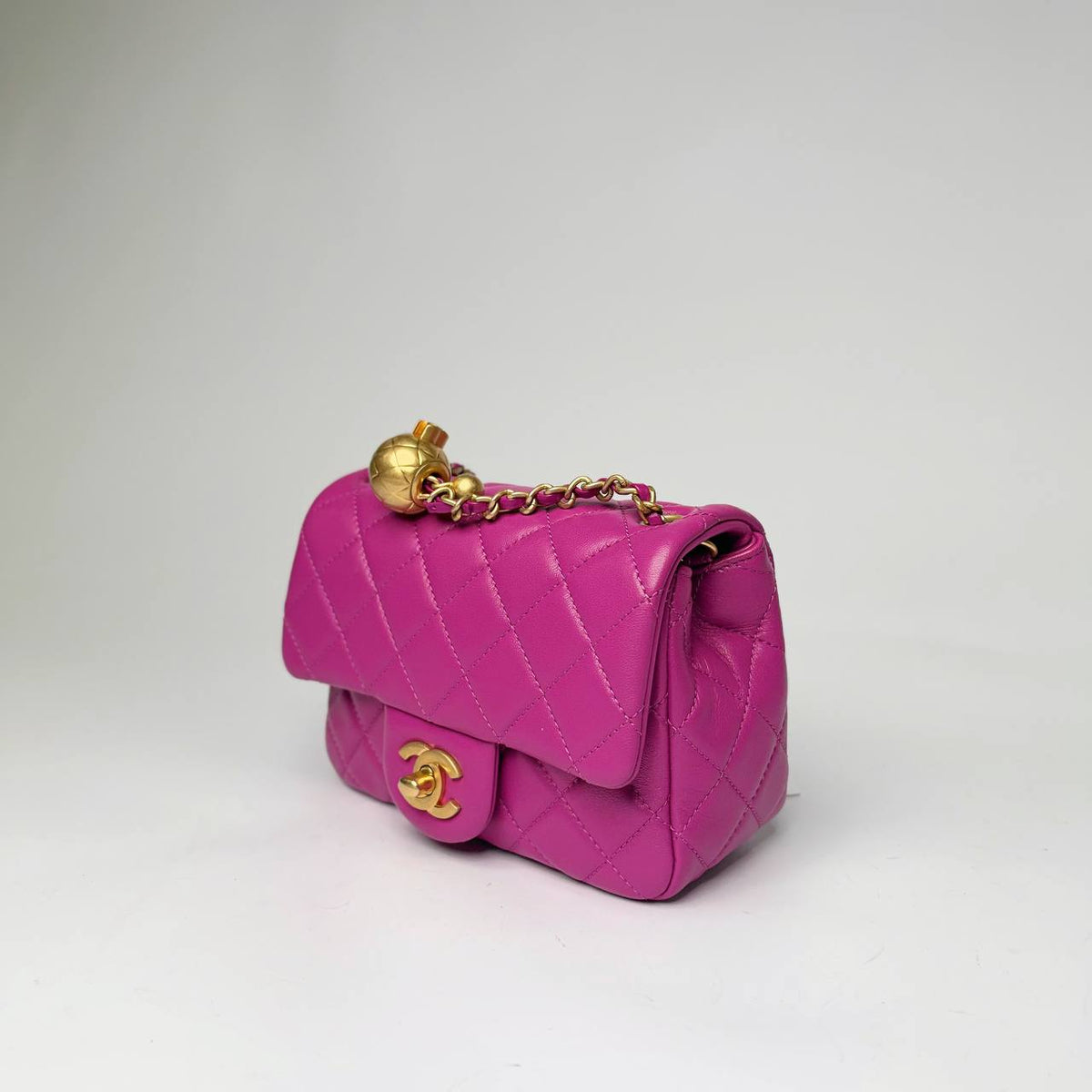 Chanel Pearl Crush Mini Square Flap Bag purple, three-quarter side view with gold ball on the chain