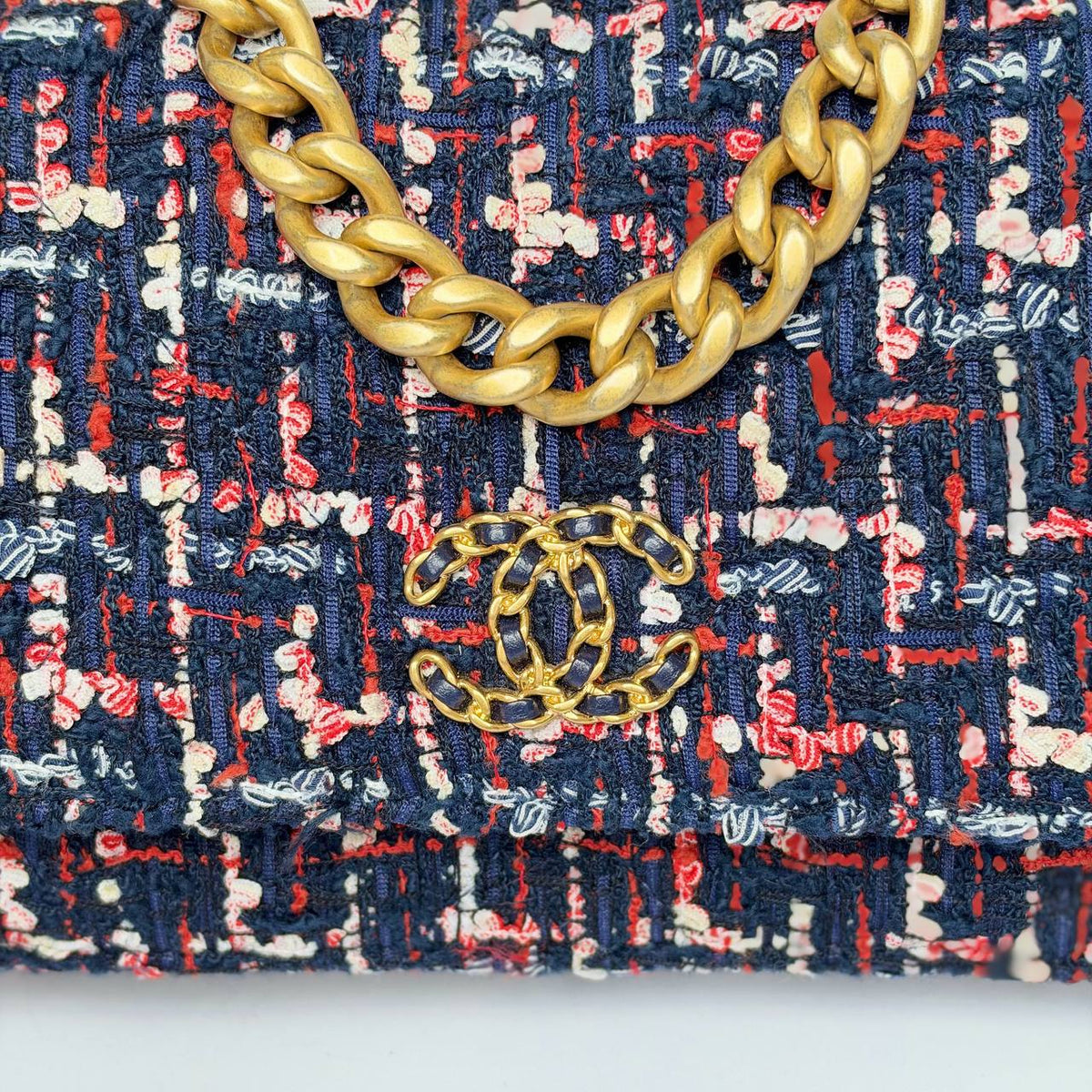 Chanel 19 Wallet on Chain navy tweed, close-up of leather-woven CC logo and chain