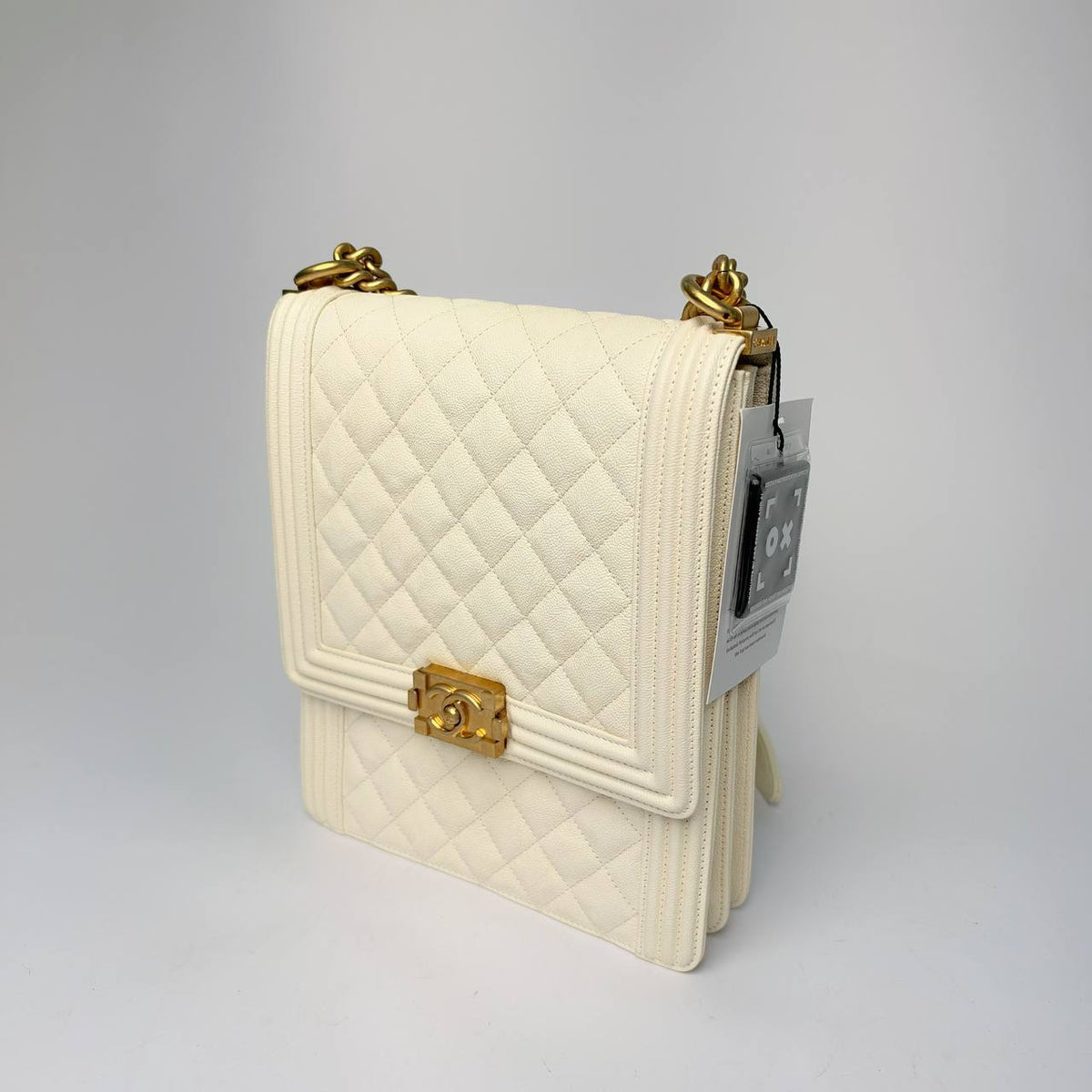 Chanel North South Boy Bag white caviar, three-quarter side view with chain strap