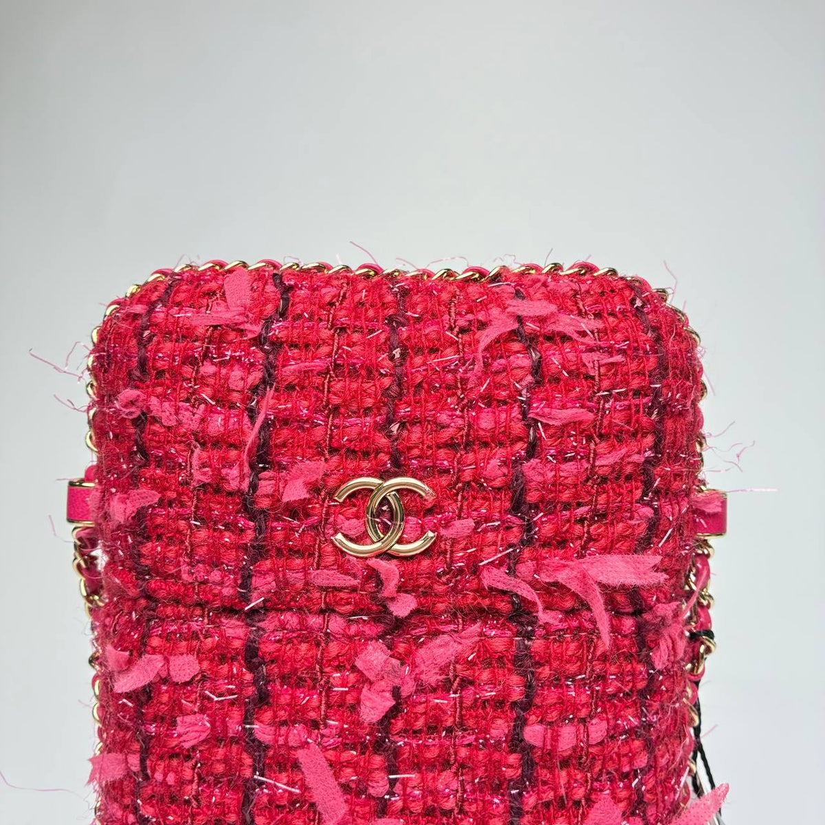 Chanel Tweed Chain Around Phone Holder, close-up of the gold CC logo and chain-trimmed edge