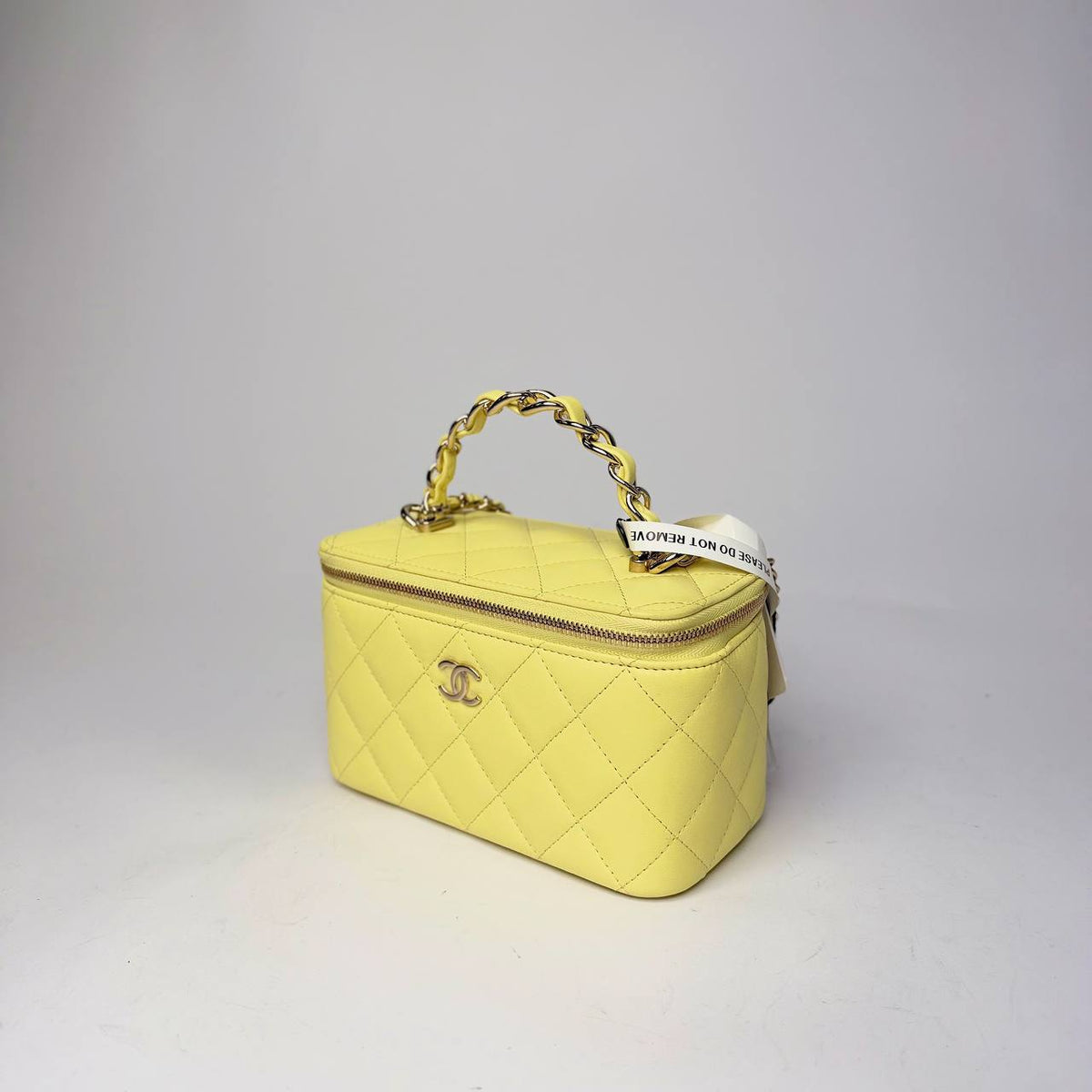 Chanel Top Handle Vanity Case yellow, angled side view of leather-woven chain handle