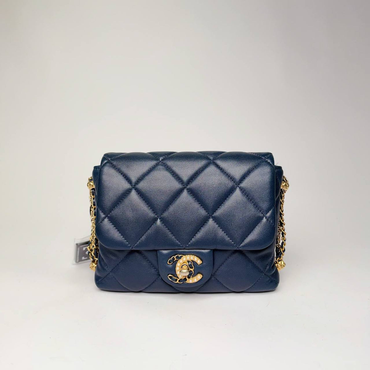 Chanel mini flap bag in navy quilted lambskin with gold-tone hardware, front view