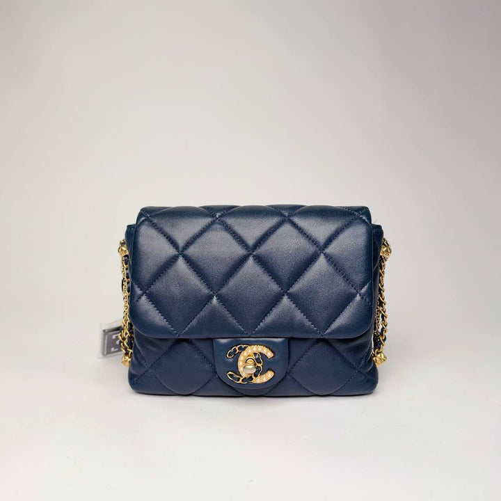 Chanel mini flap bag in navy quilted lambskin with gold-tone hardware, front view