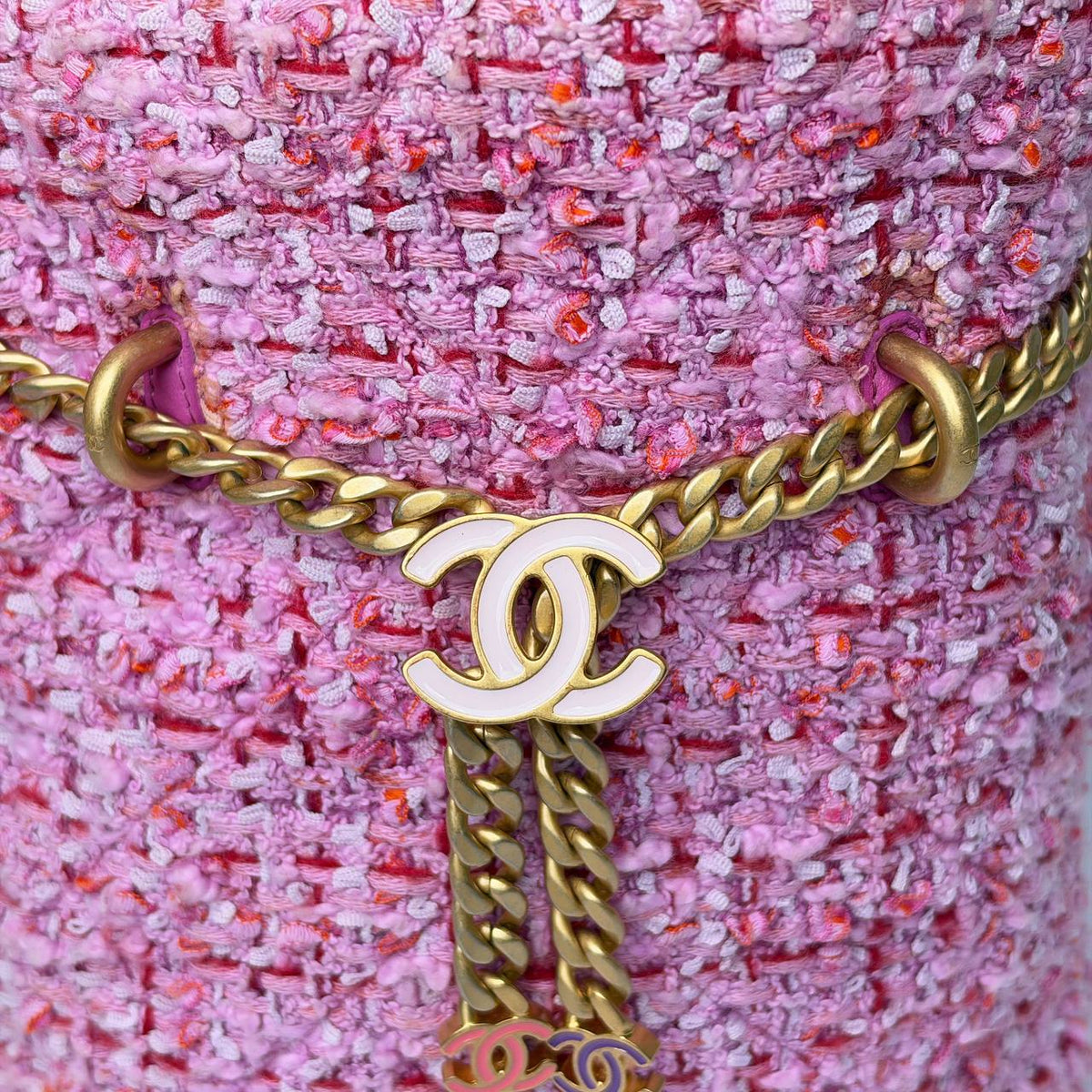 Chanel Tweed Bucket Bag pink, close-up of the white CC charm and gold chain drawstring