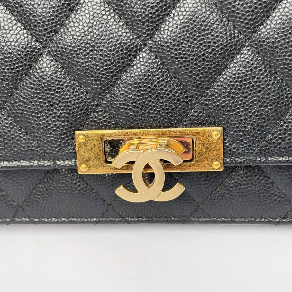 Chanel Golden Class Wallet on Chain black, close-up of the gold CC turnlock and plate on caviar leather