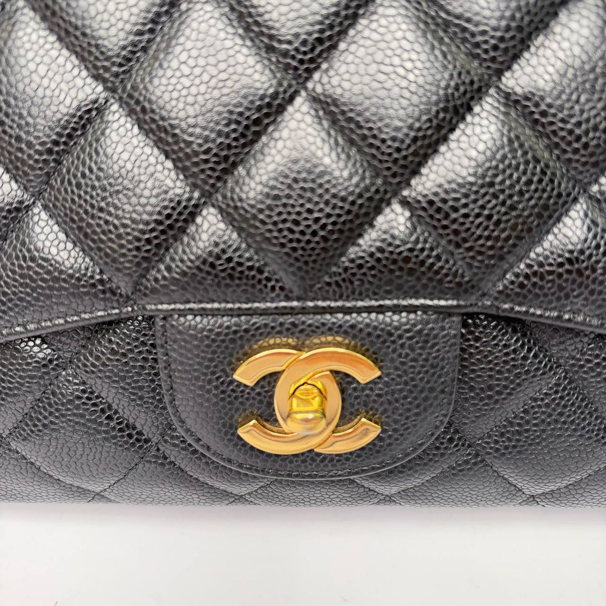 Chanel Jumbo Single Flap Bag black caviar, close-up of CC turnlock