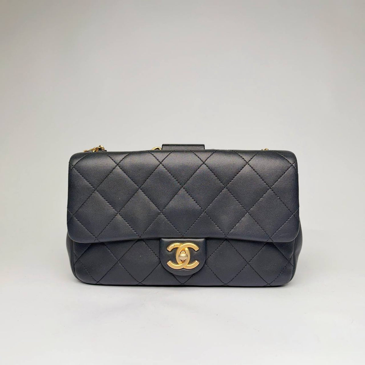 Chanel quilted flap bag in black lambskin with aged gold-tone CC turnlock and chain, front view