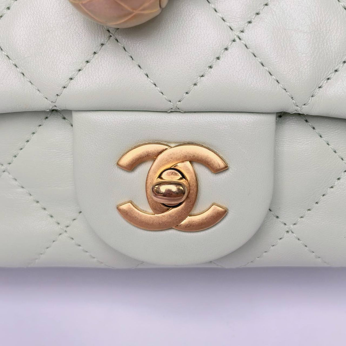 Chanel Pearl Crush Mini Flap Bag light green, close-up of the gold-tone CC turnlock