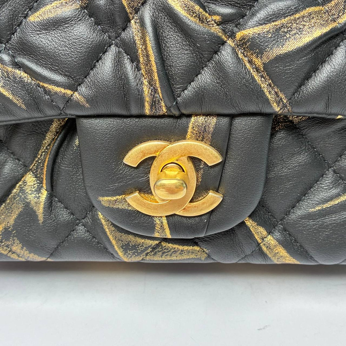 Chanel Mini Rectangular Flap Bag black and gold, close-up of CC turnlock