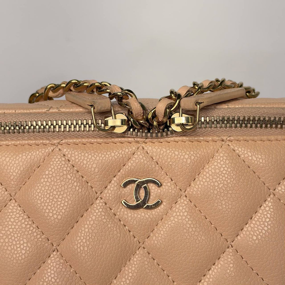 Chanel Small Vanity Case light beige, close-up of the zipper pulls, chain and CC logo on caviar