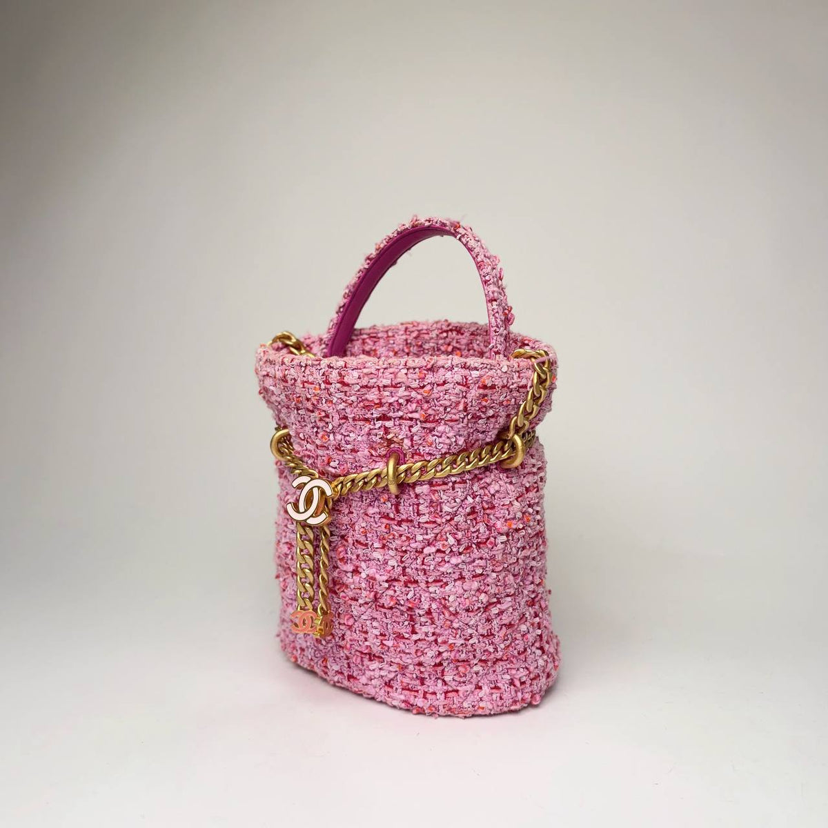 Chanel Tweed Bucket Bag pink, three-quarter side view with top handle and chain