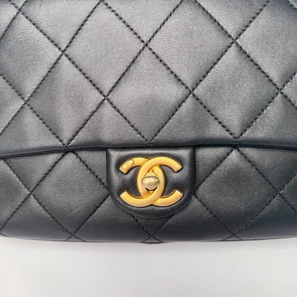 Chanel quilted flap bag black lambskin, close-up of CC turnlock